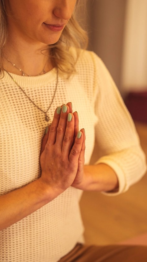 Mãos de Gabi unidas durante uma pausa na prática